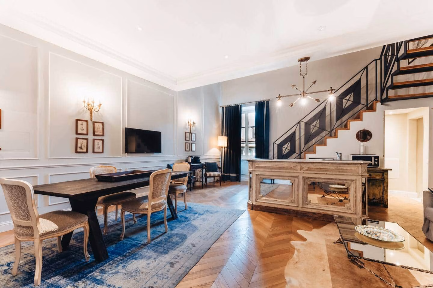 Comfort Suite, Santa Croce — soggiorno con boiserie, tappeto blu e scala scultorea in ferro