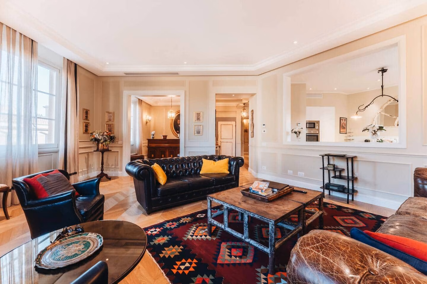 Luxury Suite with Terrace — soggiorno con divano Chesterfield in pelle nera, parquet a spina di pesce e tappeto kilim