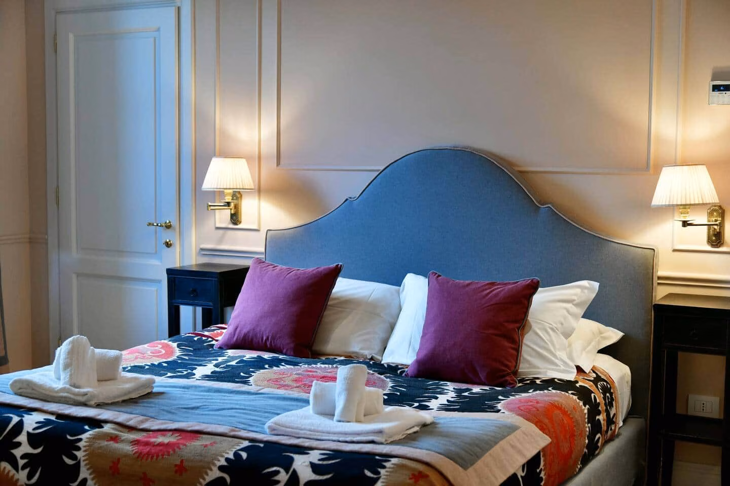 Luxury Suite with Terrace — camera matrimoniale con testiera imbottita blu e applique in ottone